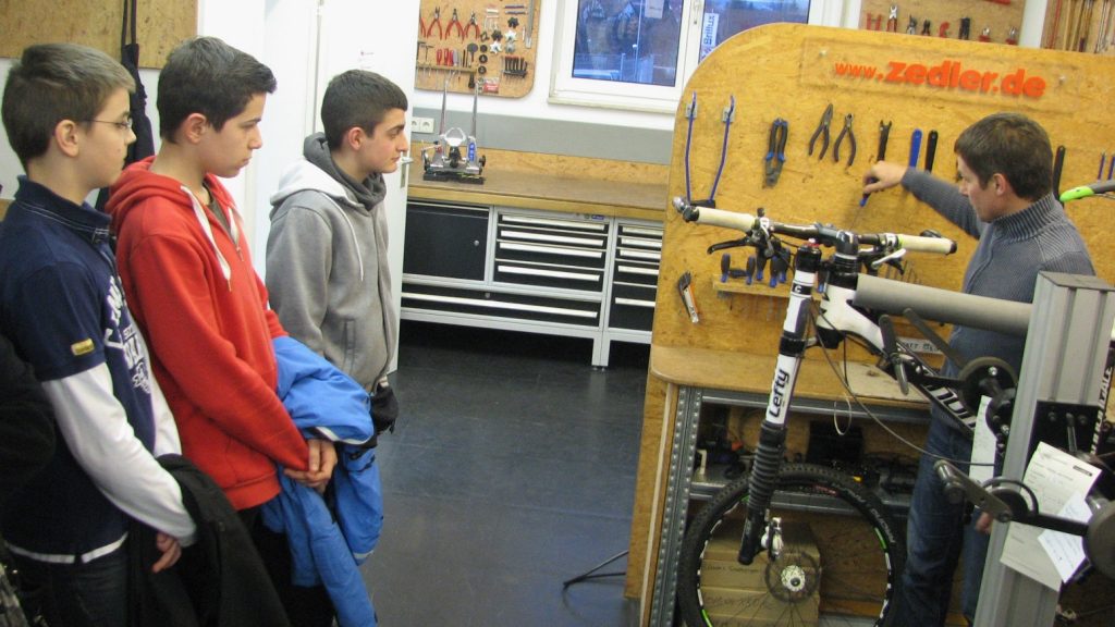 Dirk Zedler gibt Schülern einen Einblick in eine Fahrradwerkstatt.  Foto: Zedler