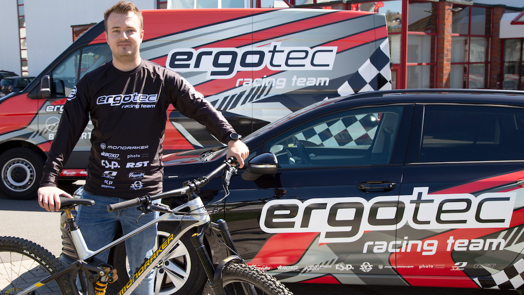 Dennis Diete mit MTB vor Ergotec Racing Team Fahrzeugen